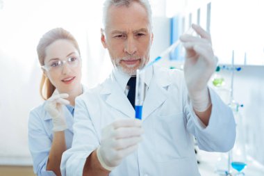 Mavi sıvıyı bazı damla ekleyerek ciddi sakallı Uygulayıcı