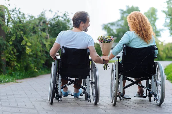 Vista trasera de una pareja de discapacitados mayores descansando en el parque — Foto de Stock