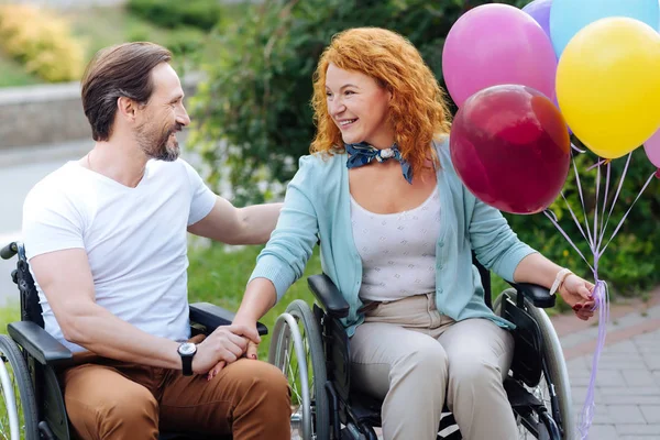 Positiv senior wheelchaired par vilar i parken — Stockfoto