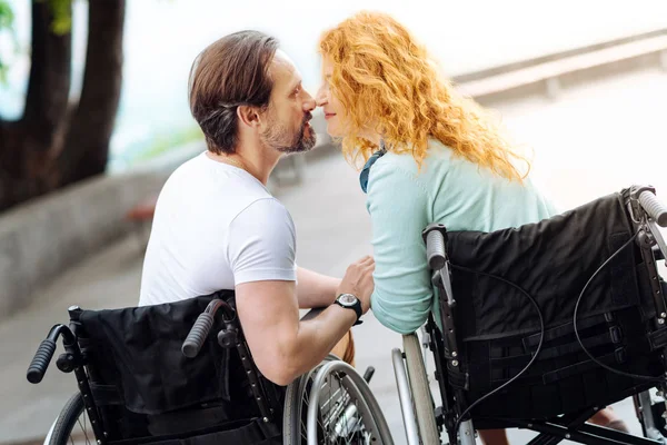 Agradable pareja de ancianos con silla de ruedas sentados nariz a nariz —  Fotos de Stock