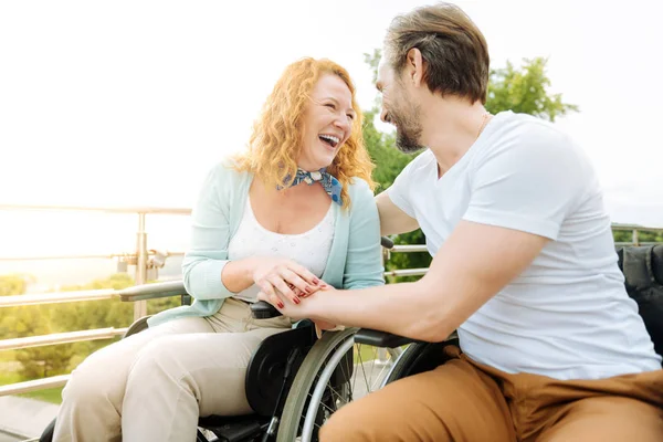 Alegre pareja mayor sititng en las sillas de ruedas al aire libre —  Fotos de Stock