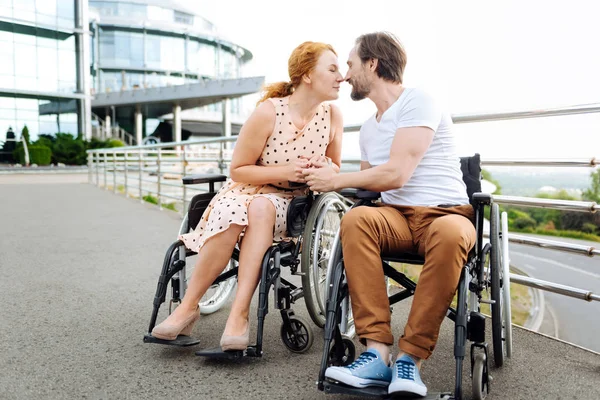 Pleasant uitgeschakeld senior paar zoenen buitenshuis — Stockfoto