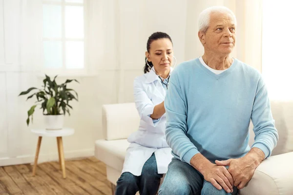 Smart médecin sérieux assis derrière sa patiente — Photo