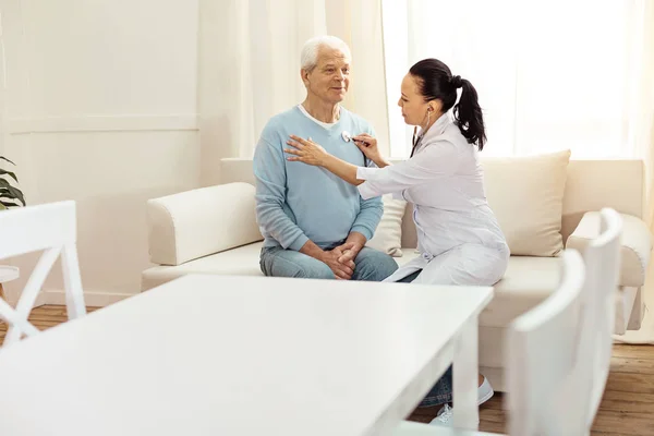 Fröhlicher positiver Mann genießt seine medizinische Untersuchung — Stockfoto