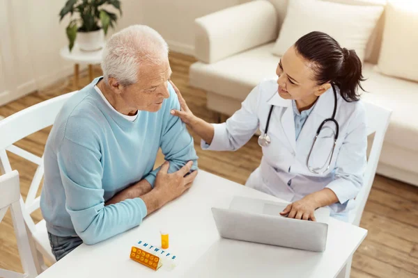 Alegre médico amigable consolando a su paciente — Foto de Stock