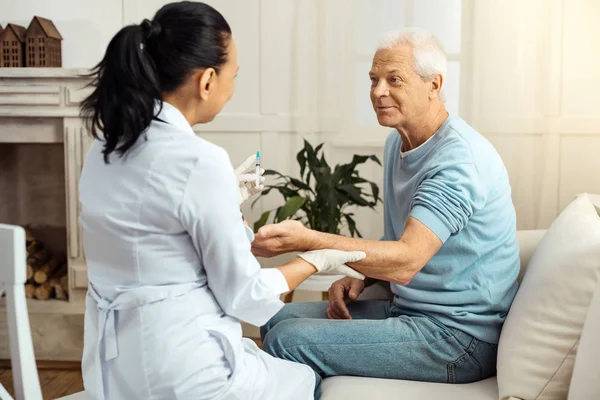 Aangename aardige verpleegster bezit is van de hand van haar patiënten — Stockfoto