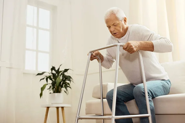 Trevlig ihållande man står upp från soffan — Stockfoto