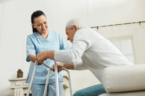 Joyful nice woman helping an elderly man — Stock Photo, Image