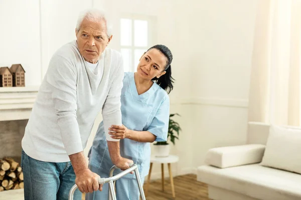 Prettige professionele verzorger bezit is van de hand van haar patiënten — Stockfoto