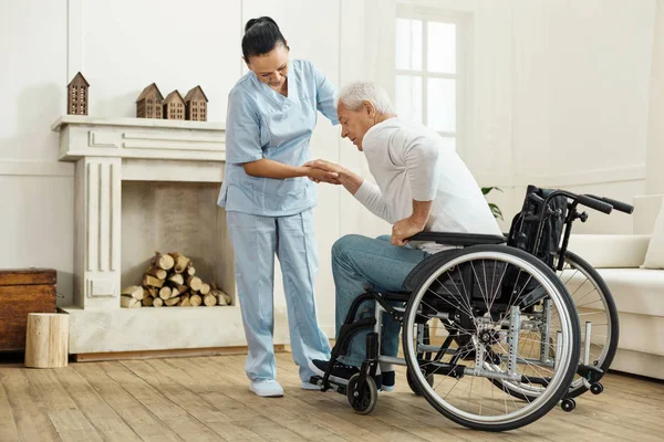 Милый пожилой человек выходит из инвалидного кресла — стоковое фото