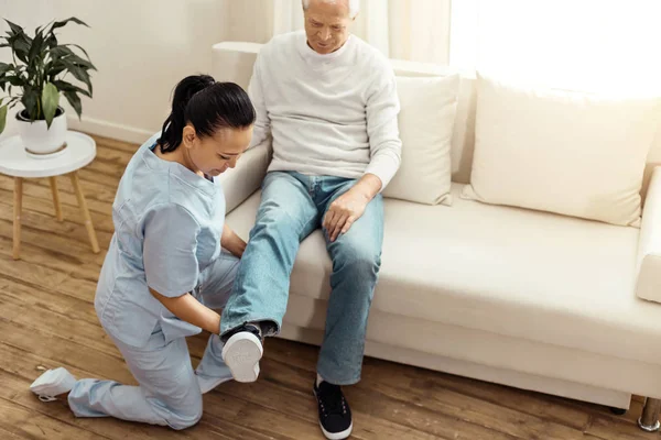Berufserfahrene Pflegekraft wärmt ihren Patienten das Bein — Stockfoto