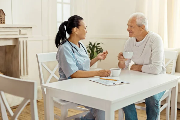 Freudig entzückter Mann hört seiner Betreuerin zu — Stockfoto