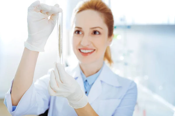 Assistente de laboratório encantador examinando amostra de orelha — Fotografia de Stock