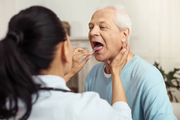 Skillful smart doctor checking her patient Stock Photo