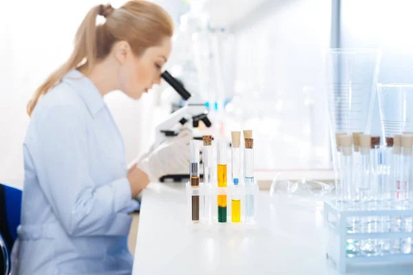 Profile photo of serious assistant that looking into microscope — Stock Photo, Image