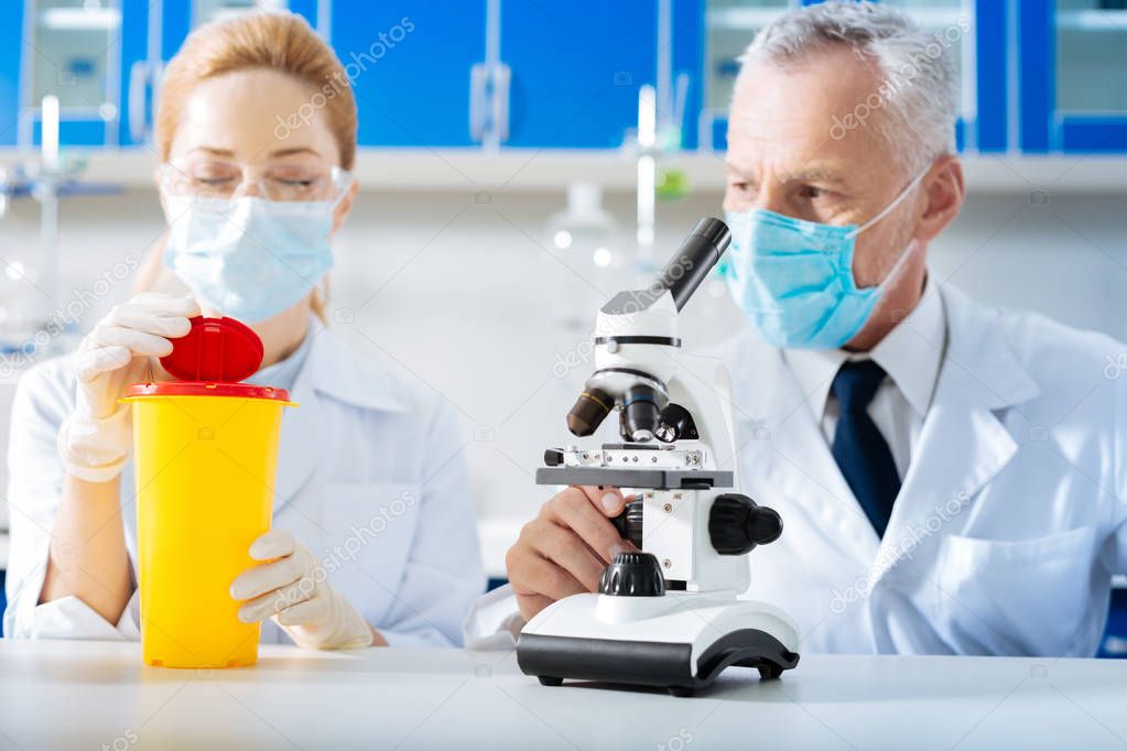 Cheerful blonde worker holding yellow plastic cup