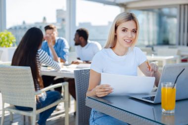 Okurken kameraya gülümseyen kız öğrenci