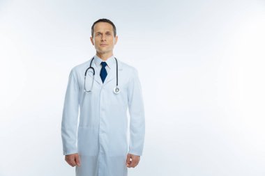 Beyaz arka plan üzerinde beyaz paltolu emin olgun doktor