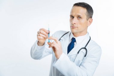 Kameraya bakarak şırınga ile kendine güvenen tıbbi işçi