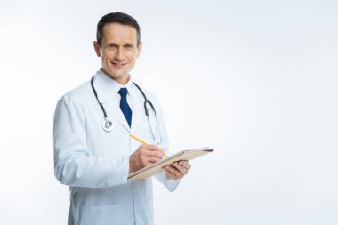 Kameraya gülümseyen defter ile neşeli erkek doktor