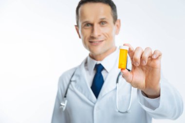 Hekim gösteren plastik şişe hap dolu gülümsüyor