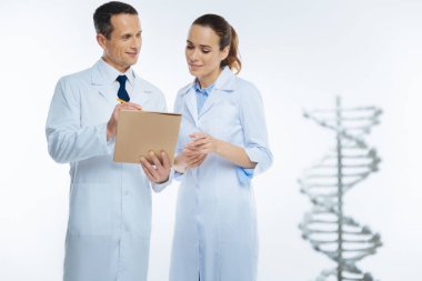 Tıbbi iş arkadaşları genetik tartışırken notlar yapma