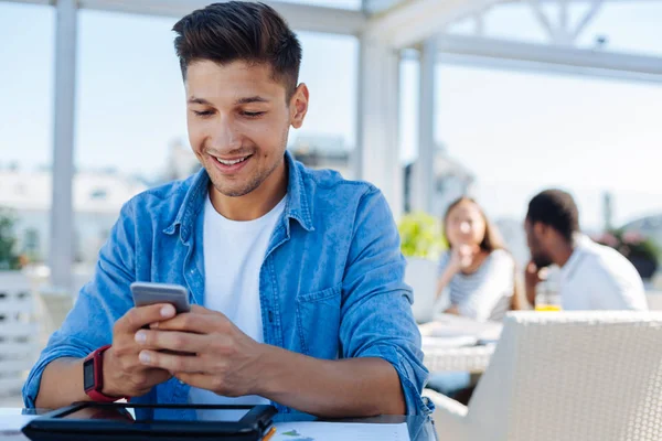 Glad ung man läsa SMS på telefon — Stockfoto