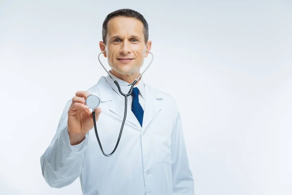 Zadowolony pracownik medyczny za pomocą stetoskopu na jasnym tle — Zdjęcie stockowe