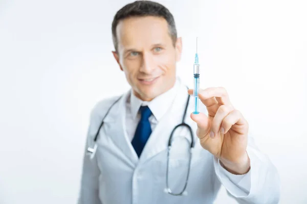 Syringe met vaccin gehouden door vrolijke medische werknemer — Stockfoto