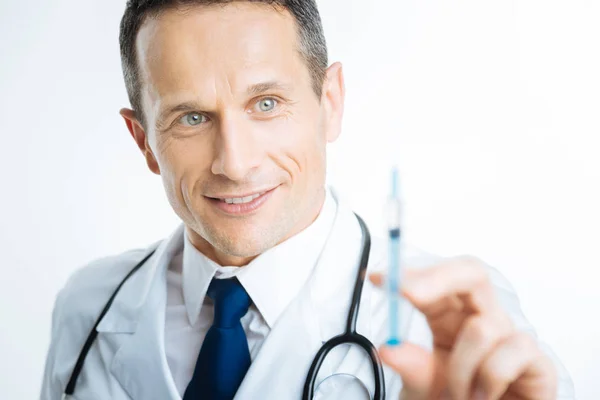 Close up portrait of practitioner looking at syringe — Stock Photo, Image