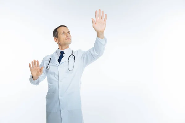 Reife männliche Arzt versucht, unsichtbaren Bildschirm berühren — Stockfoto