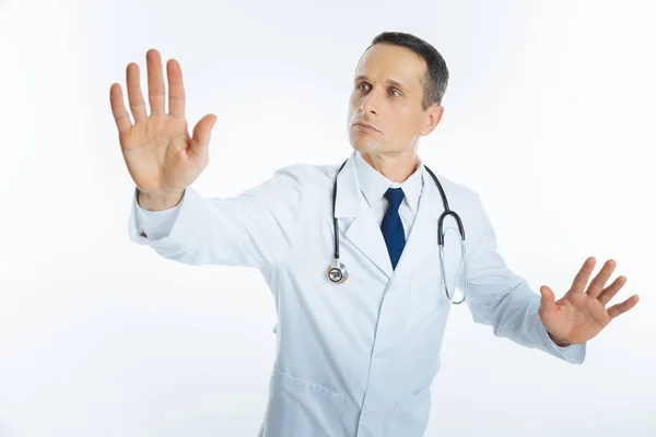 Muž lékař s stetoskop dotýká neviditelné clony — Stock fotografie