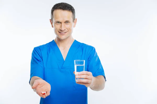 Travailleur médical consciente posant avec de l'eau et des pilules — Photo