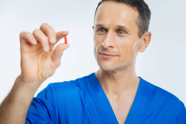 Close up portrait of cheerful physician holding pill — Stock Photo, Image