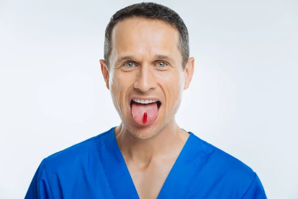 Vzrušený zdravotnického pracovníka zobrazeno jazyk s pilulka — Stock fotografie