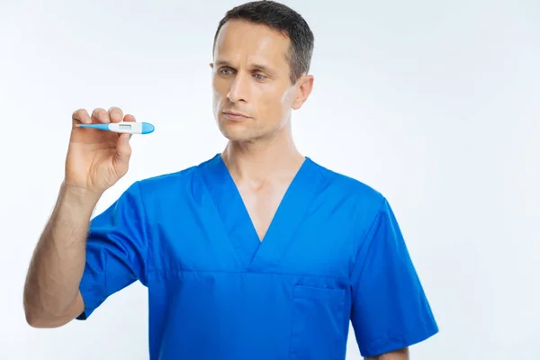 Mężczyzna lekarz ogląda Termometr elektroniczny — Zdjęcie stockowe