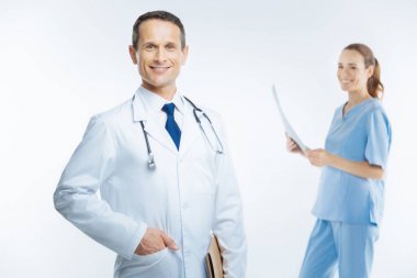 Beyaz önlük kameraya gülen içinde neşeli hekim