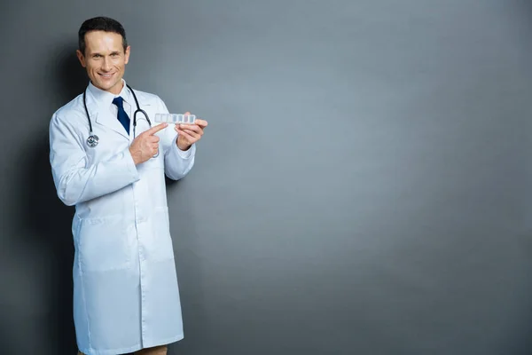 Experienced physician pointing toward weekly organizer for prescription — Stock Photo, Image