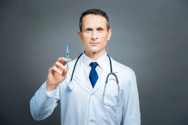 Portrét starší doktor pózuje s injekční stříkačkou — Stock fotografie