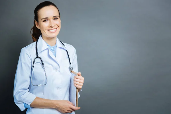 Médecin féminin joyeux avec stéthoscope posant pour caméra — Photo