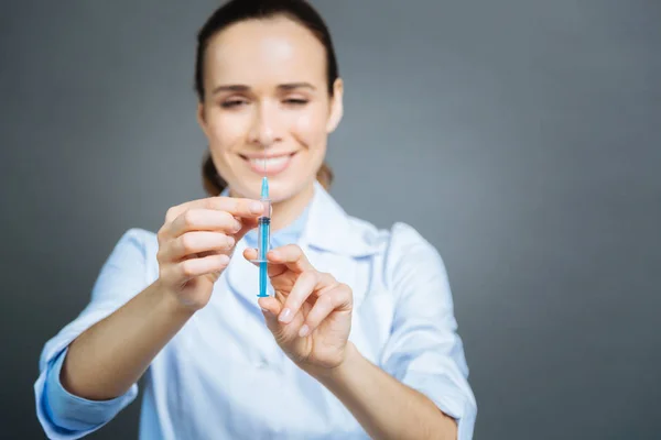 Médico de mente positiva verificando a seringa antes da injeção — Fotografia de Stock