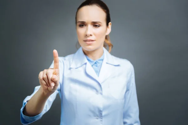 Serious female practitioner touching invisible screen — Stock Photo, Image