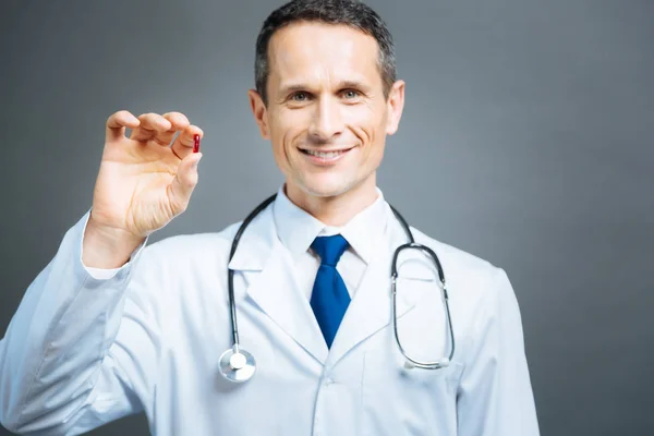 Selektiver Fokus auf rote Tablette in der Hand eines männlichen Arztes — Stockfoto