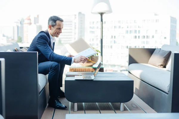 Cheerful successful businessman holding a folder with documents — Stock Photo, Image