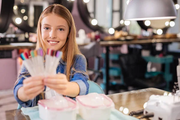 Linda menina adolescente posando com uma paleta de cores esmalte — Fotografia de Stock