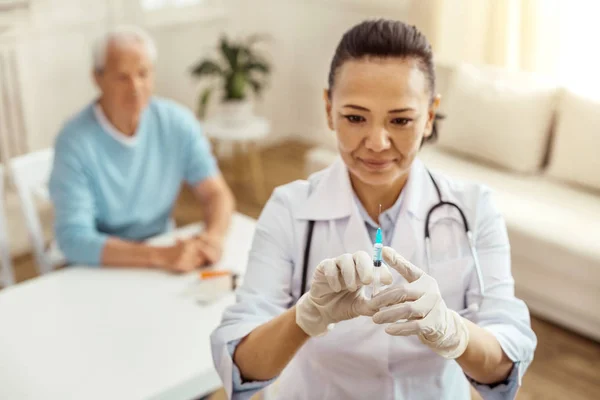 Fröhlich positive Krankenschwester testet die Spritze — Stockfoto
