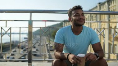 Korkuluk yakın oturan gülümseyen Hintli adam