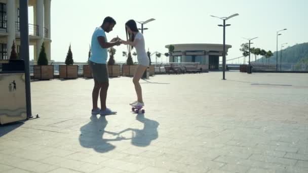 Romantic couple practicing skateboarding on the city street — Stock Video