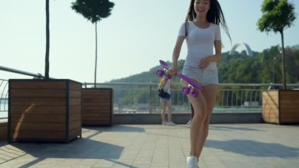 Attractive young girl jumping and spinning against city background — Stock Video