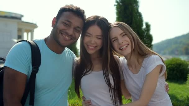 Optimistische vrolijke vrienden knuffelen en glimlachen — Stockvideo
